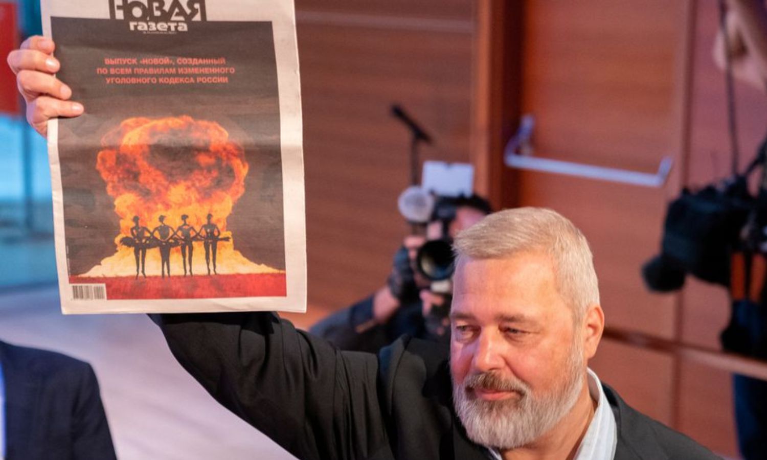 ديمتري موراتوف يحمل نسخة من جريدته "نوفيا جازيتا" بعد بيع ميداليته بجائزة نوبل للسلام لعام 2021 مقابل 103.5 مليون دولار (رويترز)
