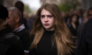 امرأة تبكي خلال جنازة ثلاثة من العسكريين الأوكرانيين ميلنيك أندري وشوفرين أندري وأنكراتوف أولكساندرا الذين قتلوا في لفيف شرقي أوكرانيا السبت 14 من أيار 2022 (AP)