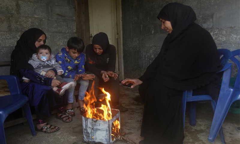 لاجئون سوريون يدفئون أنفسهم حول حريق خارج منزلهم الصغير ، في قرية صرفند بالقرب من مدينة صيدا الساحلية الجنوبية في لبنان- 2 من كانون الثاني 2022 (AF)
