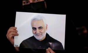 امرأة إيرانية تحمل صورة قاسم سليماني في إيران خلال حفل لإحياء الذكرى الثانية لمقتله_ 3 من كانون الثاني 2022 (رويترز)