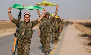 تعبيرية: مقاتلون ومقاتلات كرد يحملون علمهم شمال سوريا (رويترز)
