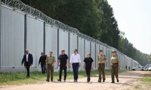 شخصيات في الحكومة البولندية قرب منطقة جدار معدني بُني حديثًا على الحدود بين بولندا وبيلاروسيا- 30 من حزيران 2022 (حرس الحدود)