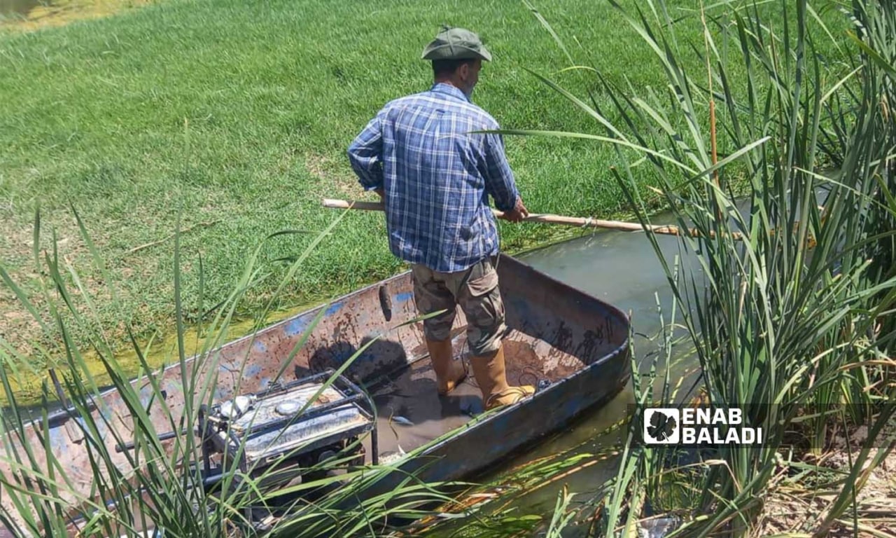 رجل يصطاد السمك في نهر العاصي في نموز 2022 (عنب بلدي/ هدى الكليب)