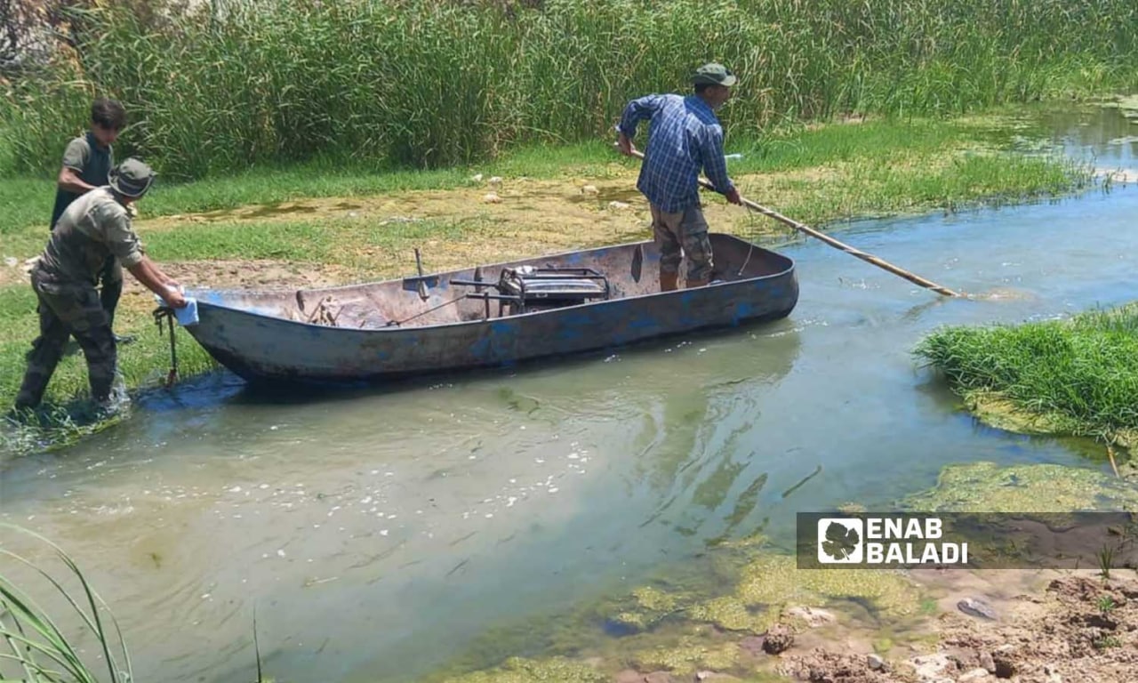 رجل يصطاد السمك في نهر العاصي في نموز 2022 (عنب بلدي/ هدى الكليب)