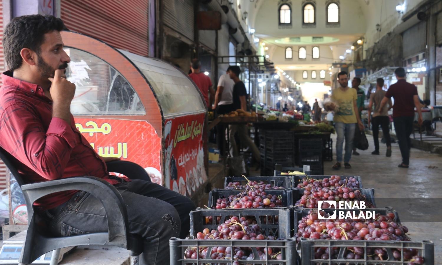  رجل يبيع العنب في السوق المسقوف بمدينة إعزاز بريف حلب الشمالي - 2 أيلول 2022 (عنب بلدي / ديان جنباز)