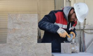 محمد لوزي حباب ، الذي فر من الحرب الدائرة في سوريا ولجأ إلى تركيا ، يلفت الانتباه إلى المنتجات الزخرفية التي صنعها من الرخام بالحرف اليدوية في مصنع للرخام بمدينة بيلجيك في تركيا - 12 شباط 2022 (الأناضول)
