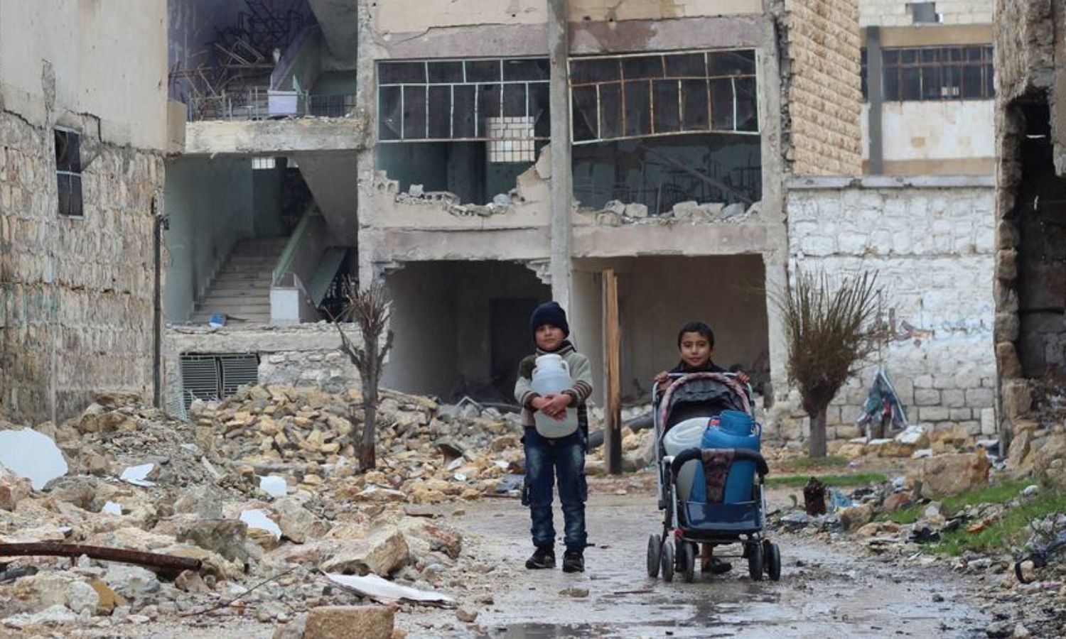 طفلان يجمعان المياه لعائلتهما في شرف حلب بسوريا (يونيسيف)