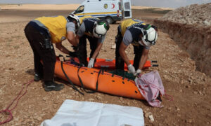 متطوعون في الدفاع المدني السوري أثناء إجلاء جثة أحد القتلى إثر الانفجار- 23 من أيلول 2022 (الدفاع المدني السوري)