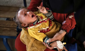 طفل مصاب بالكوليرا يتلقى العلاج في مستشفى الكسرة بمحافظة دير الزور شرقي سوريا (AFP)
