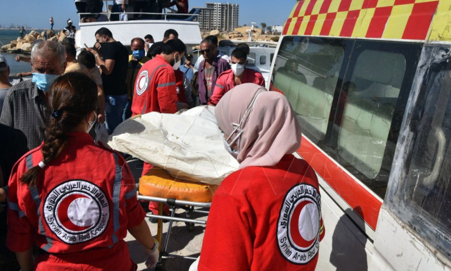 عناصر "الهلال الأحمر السوري" ينقلون ضحايا حادثة غرق المركب قبالة سواحل طرطوس- 25 من أيلول 2022 (سانا)