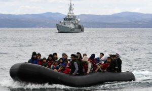 مهاجرون على متن زورق مطاطي يصلون إلى جزيرة ليسبوس اليونانية برفقة سفينة فرونتكس بعد عبور بحر إيجه من تركيا في 28 شباط 2020 (AP)