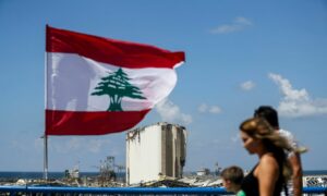 العلم اللبناني قرب حطام انفجار مرفأ بيروت - 9 آب 2022 (AFP)