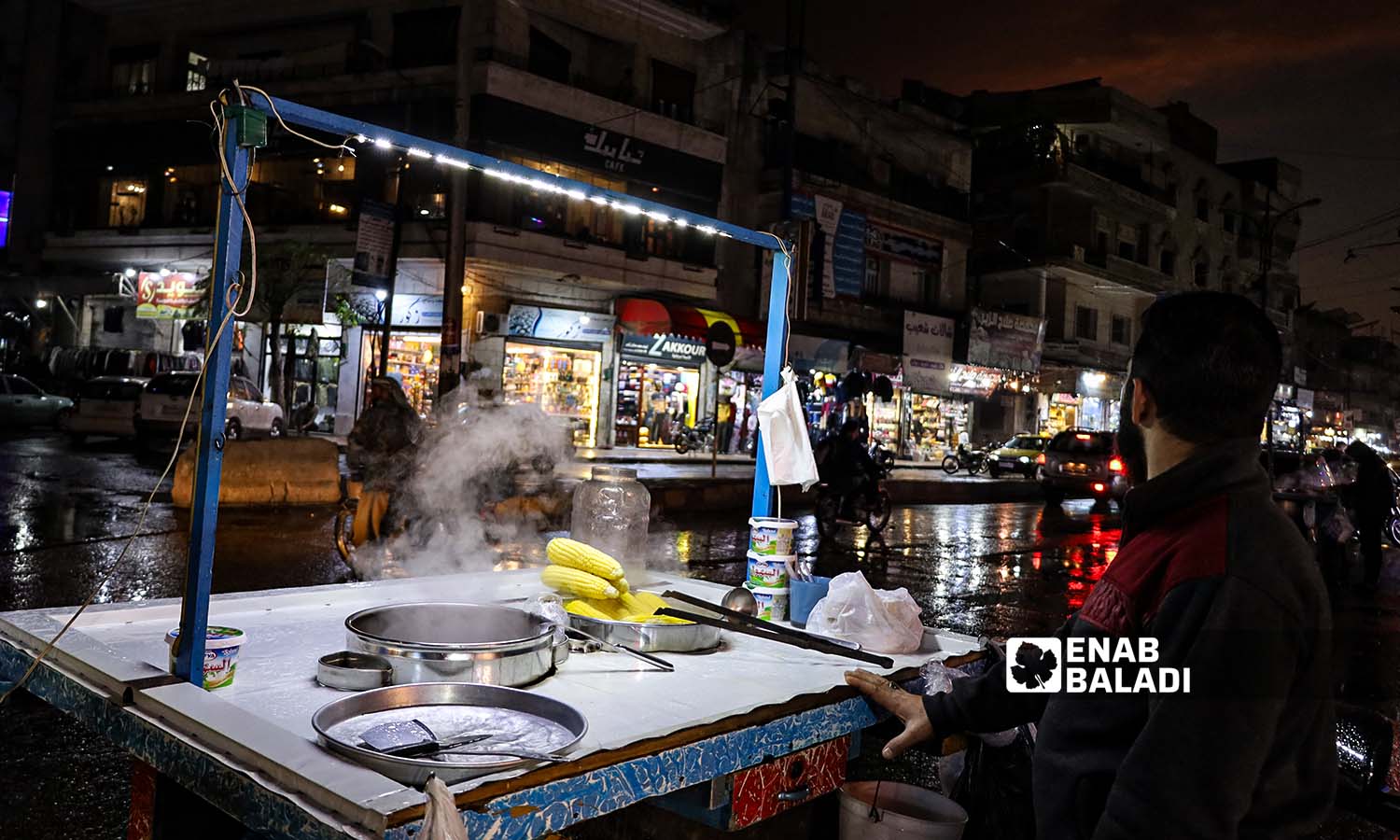 بائع متجول يبيع الذرة المسلوقة بعد يوم ماطر بالقرب من ساحة الساعة في مدينة إدلب- 25 من تشرين الثاني 2022 (عنب بلدي/ مجد هامو)