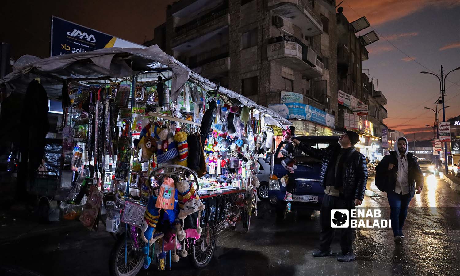 بائع متجول يقوم بمسح بضاعته من الغبار وسط سوق إدلب- 25 من تشرين الثاني 2022 (عنب بلدي/ مجد هامو)