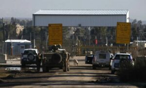 مركبة عسكرية إسرائيلية وسيارات تابعة لقوة الأمم المتحدة لفض الاشتباك عند معبر 
