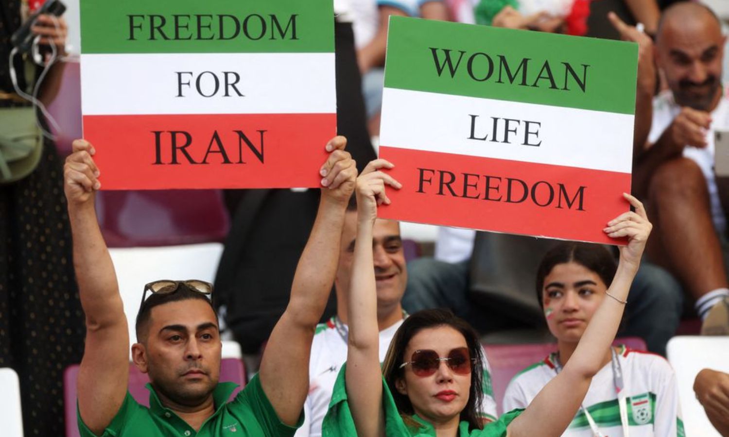 مشجعو منتخب إيران يدعمون فريقهم بشعار "حرية حياة المرأة" خلال مباراة ضد إنجلترا في المجموعة الثانية في كأس العالم لكرة القدم في قطر- 21 من تشرين الثاني 2022 (رويترز)