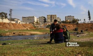 مجموعة من الأطفال يلعبون بالقرب من نهر عفرين الملوث بمياه الصرف الصحي ومخلفات المعامل- 12 من كانون الأول 2022 (عنب بلدي/ أمير خربطلي)