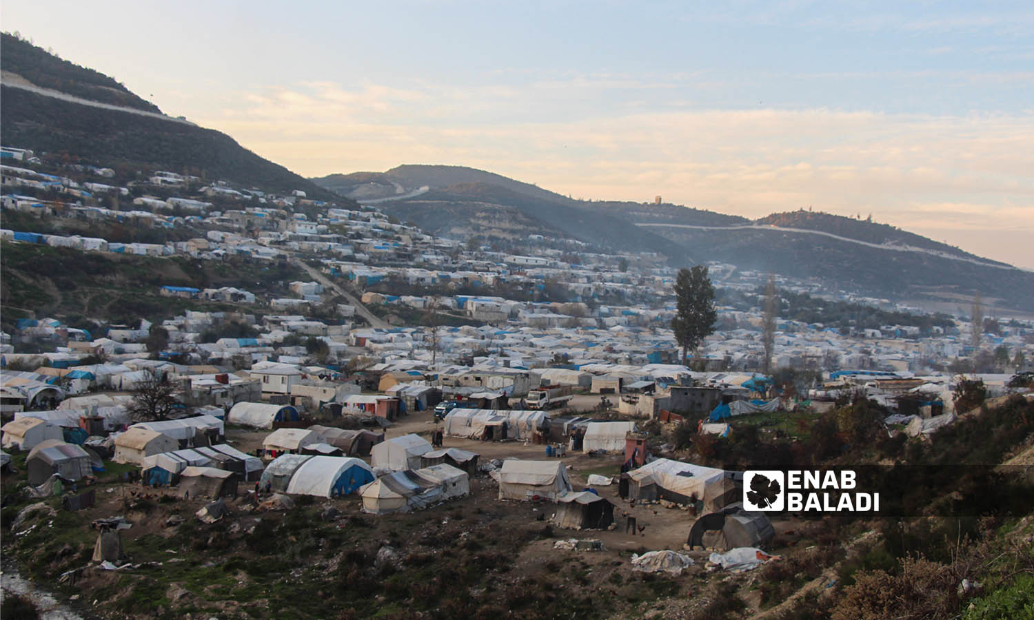 مشهد عام لمخيم خربة الجوز ومن خلفه الجدار الفاصل على الحدود السورية التركية- 23 من كانون الأول 2022(عنب بلدي/ إياد عبد الجواد)