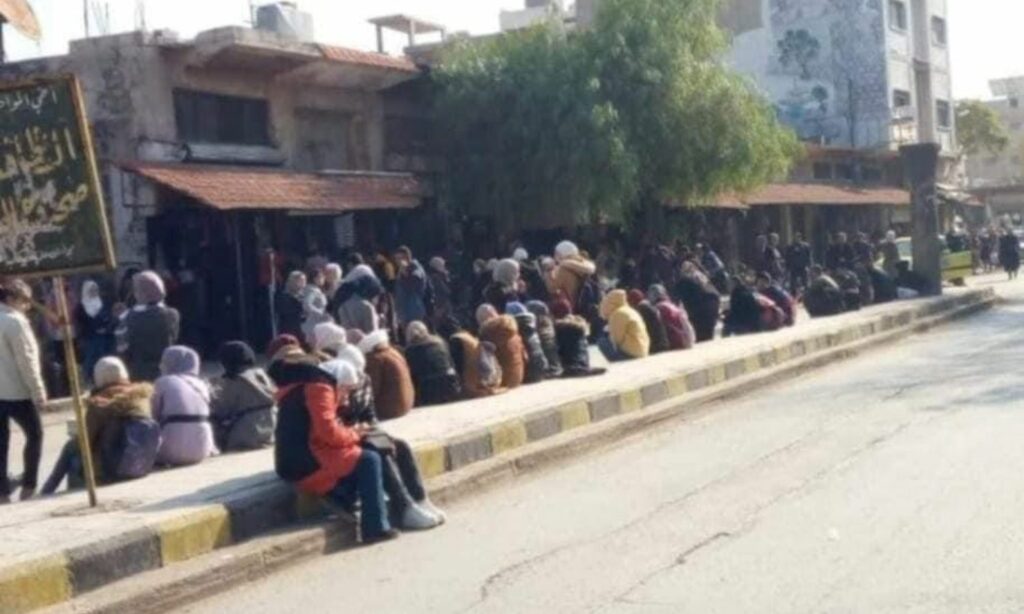 من انتظار المدنيين لحافلات النقل العامة وسط مدينة سلمية بالقرب من الساحة العامة (فيس بوك\ الإعلامي وسيم زينو)