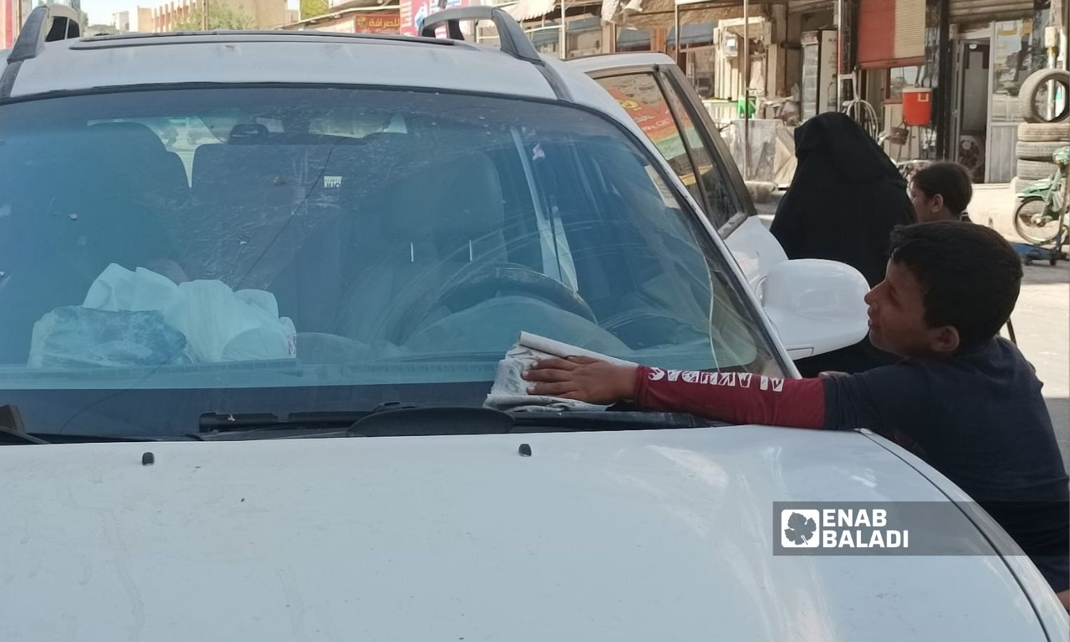 طفل يمتهن مسح السيارات في إدلب في كانون الأول 2022 (عنب بلدي/ هدى الكليب)