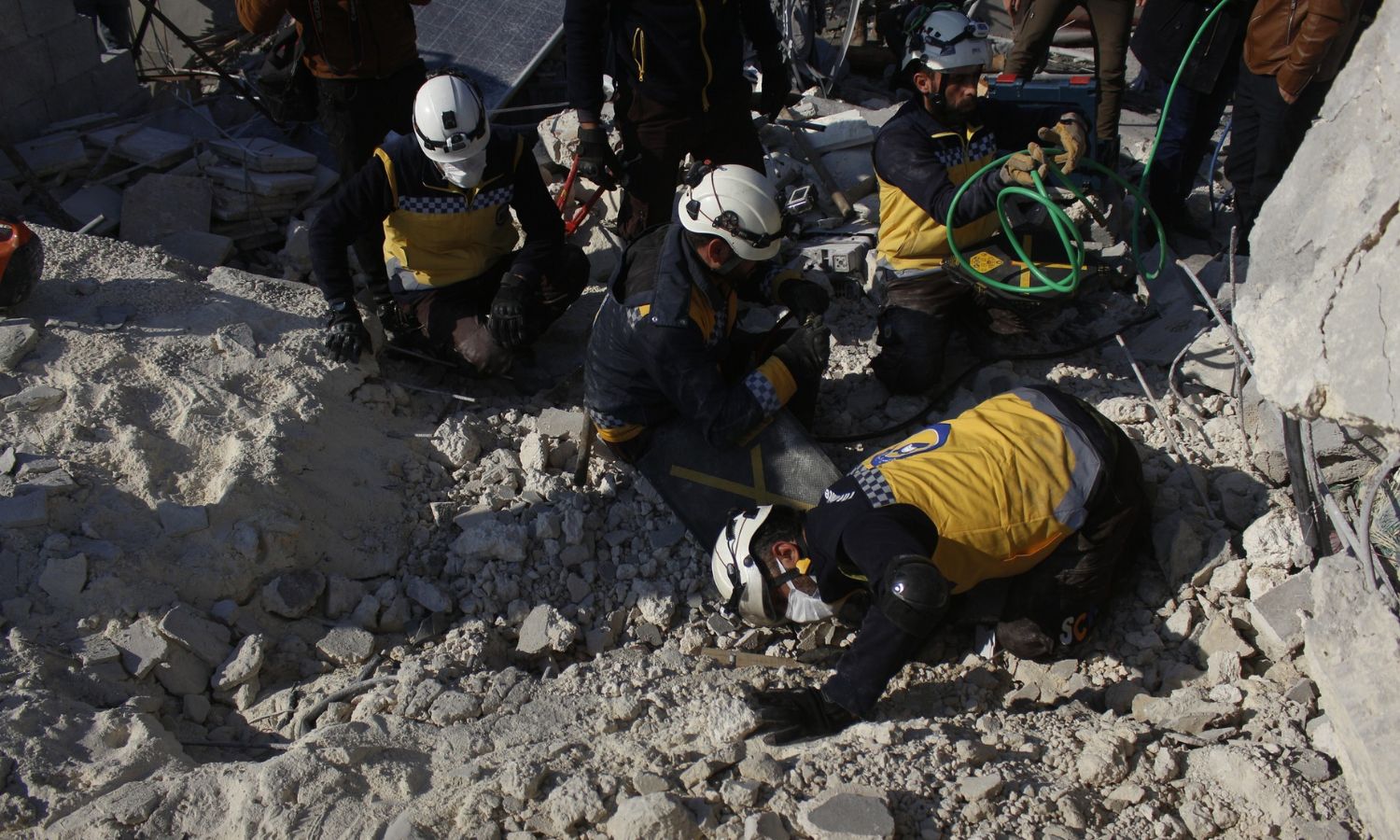 متطوعون في "الدفاع المدني السوري" يتفقدون منزلًا قصفته طائرة مسيّرة بريطانية في مدينة الباب شرقي حلب- 20 من كانون الأول 2022 (الدفاع المدني السوري/ فيس بوك)