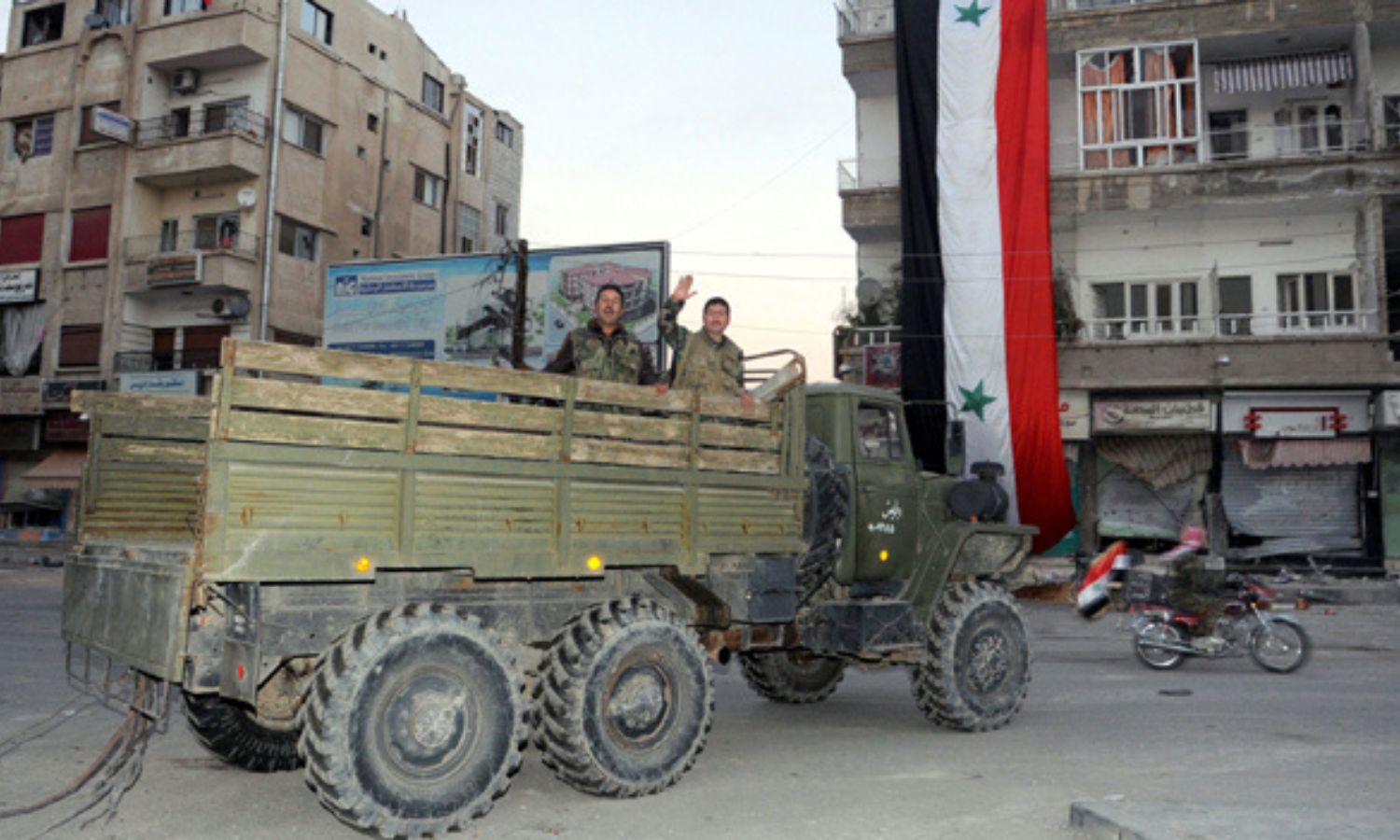 عناصر من قوات النظام السوري يستقلون مركبة عسكرية داخل مدينة النبك بريف دمشق، بعد السيطرة عليها- 9 من كانون الأول 2013 (AFP)