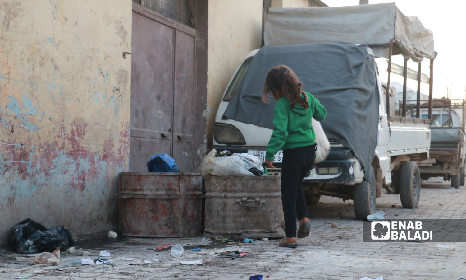طفلة ترمي قمامة في مخيم "باب السلامة القديم" بريف حلب الشمالي- 4 من كانون الأول 2022 (عنب بلدي/ ديان جنباز)