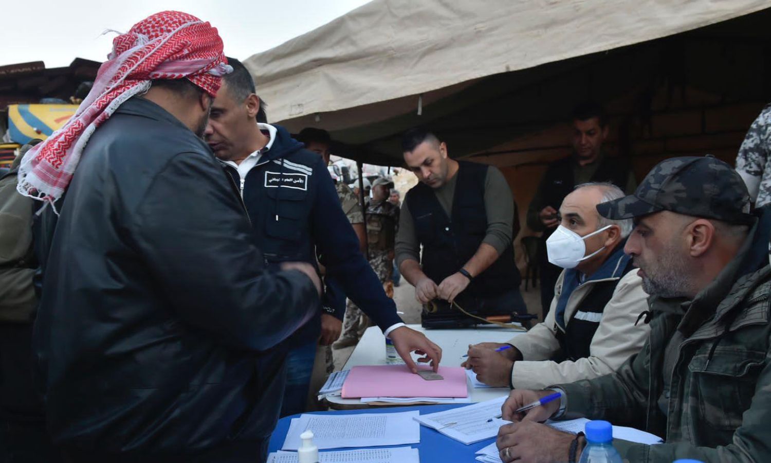 عناصر من "الأمن العام اللبناني" يشرفون على سير عملية عودة اللاجئين السوريين إلى سوريا من وادي حميد قرب بلدة عرسال الحدودية اللبنانية- 26 من تشرين الأول 2022 (النهار)