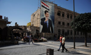 صورة لرئيس النظام السوري بشار الأسد تعلو مبنى في حلب - 2020 (AP)