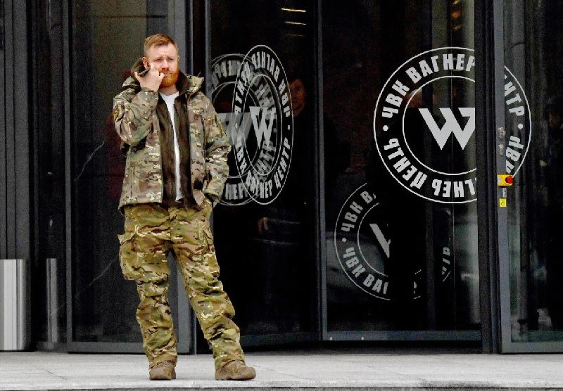 رجل يرتدي زيًا عسكريًا يقف عند مدخل مركز مجموعة فاغنر في سان بطرسبرغ، روسيا - 4 تشرين الثاني 2022 (AFP)