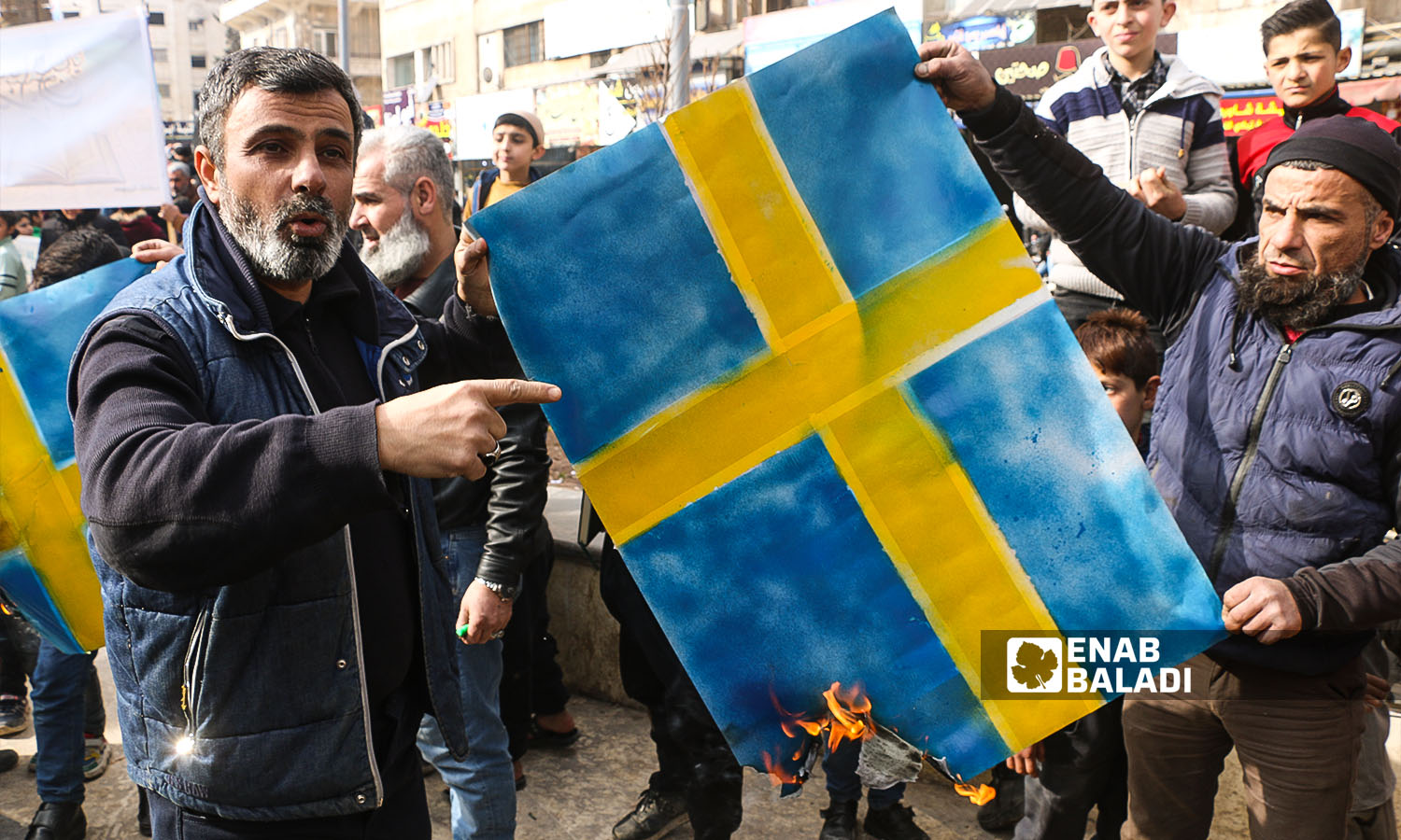 متظاهرون يحرقون العلم السويدي في مدينة إدلب احتجاجًا على حرق نسخة من المصحف في السويد- 27 كانون الثاني 2023 (عنب بلدي/أنس الخولي)