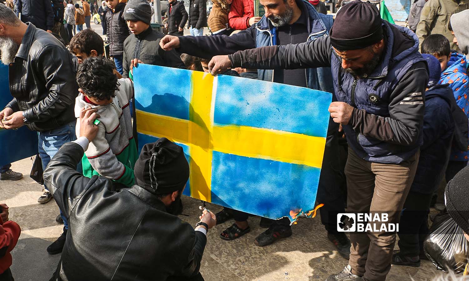 متظاهرون يحرقون العلم السويدي في مدينة إدلب احتجاجًا على حرق نسخة من المصحف في السويد- 27 كانون الثاني 2023 (عنب بلدي/أنس الخولي)