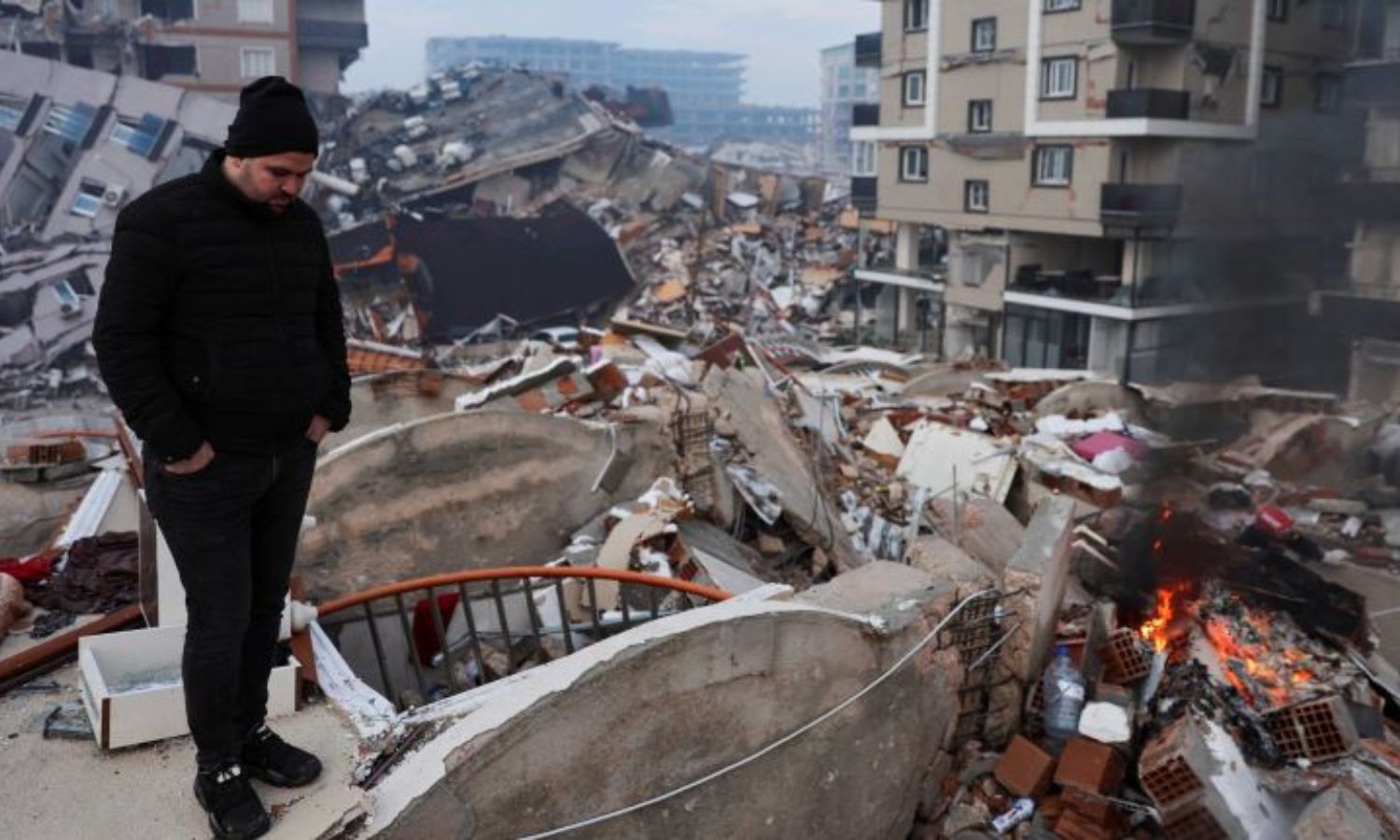 رجل يقف وسط الأنقاض ينظر إلى الأضرار التي أعقبت الزلزال الذي وقع في تركيا - 7 شباط 2023 (رويترز)