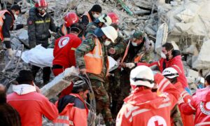 عناصر من الصليب الأحمر اللبناني ينقلون على نقالة جثة ضحية انتشلت من تحت أنقاض مبنى منهار في مدينة جبلة- 9 شباط 2023(AFP)