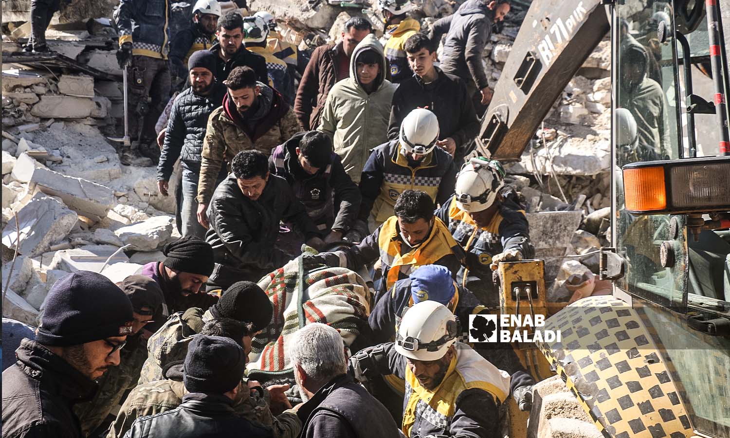 متطوعون ينقلون أحد المصابين العالقين تحت الركام في منطقة أرمناز إثر زلزال ضرب مناطق شمال غربي سوريا- 7 شباط 2023 (عنب بلدي/ إياد عبد الجواد)
