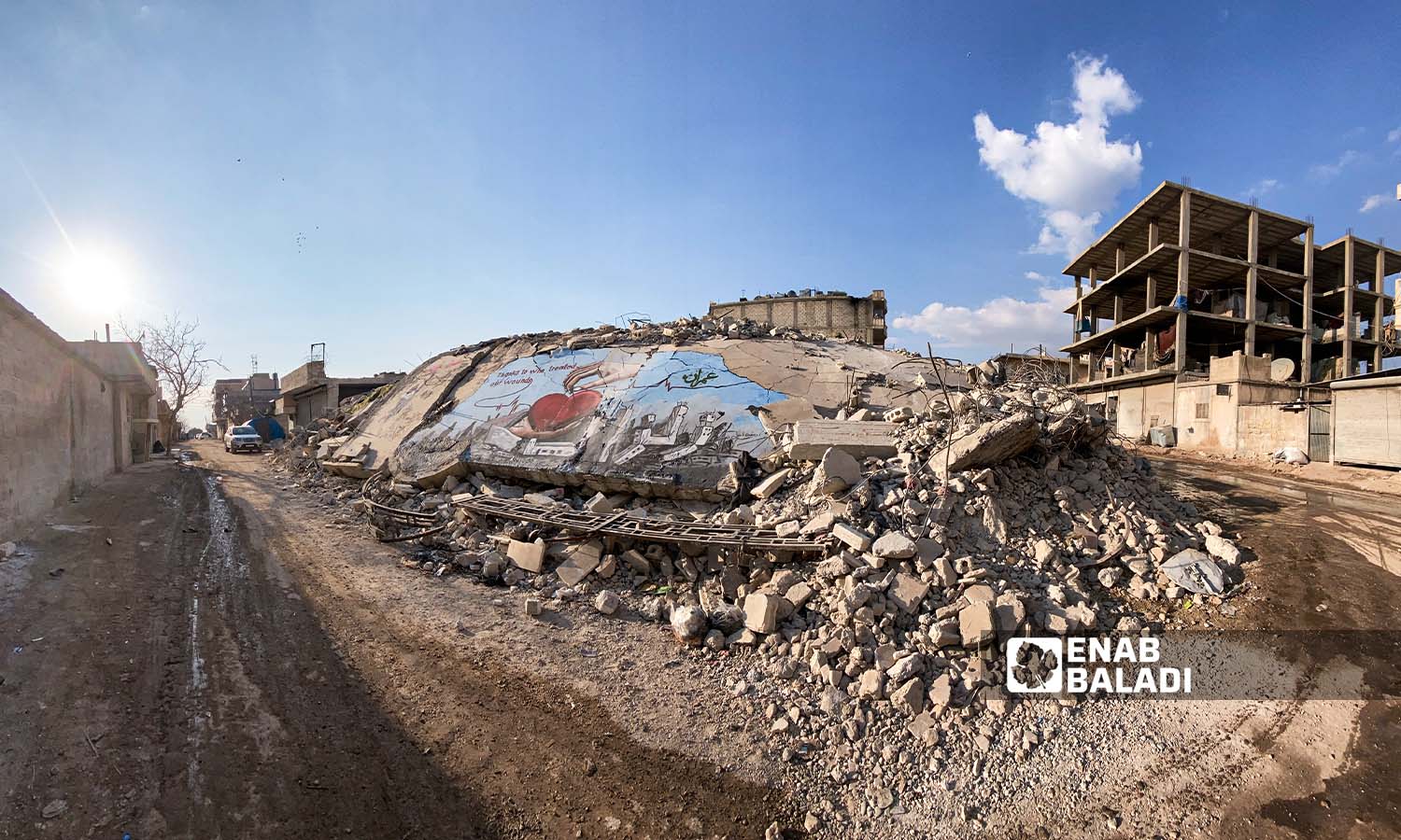 رسومات جرافيتي فوق ركام الأبنية الذي دمرها الزلزال في مدينة جنديرس بريف حلب - 24شباط 2023 (عنب بلدي/ أمير خربطلي)