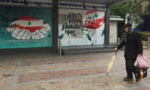 رجل يمر أمام مفرع مغلق لبنك بيروت في مدينة صيدا اللبنانية- 27 شباط 2023 (رويترز)