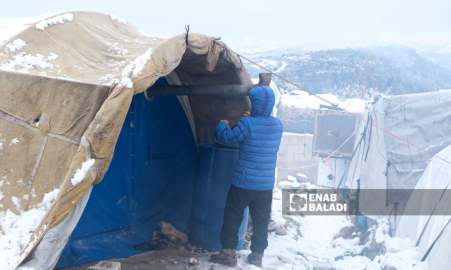 رجل يصلح تمديدات التدفئة  الخيمة في مخيم الزوف بجسر الشغور - 5شباط 2023 (عنب بلدي/محمد نعسان دبل)