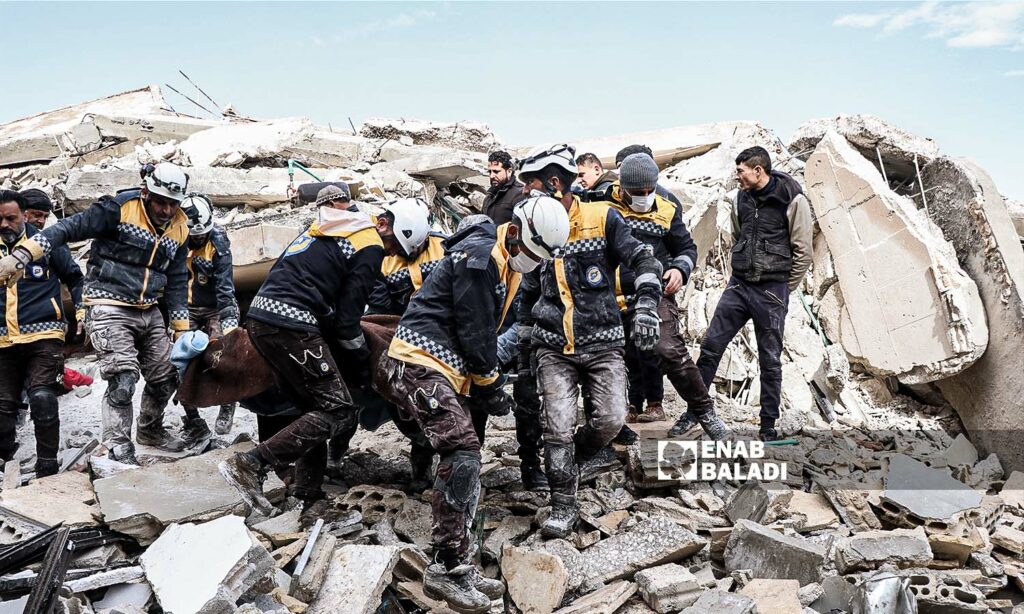 متطوعون من "الدفاع المدني السوري" ينقلون أحد الضحايا العالقين تحت الركام في منطقة عزمارين إثر زلزال ضرب مناطق شمال غربي سوريا- 7 شباط 2023 (عنب بلدي/محمد نعسان دبل)