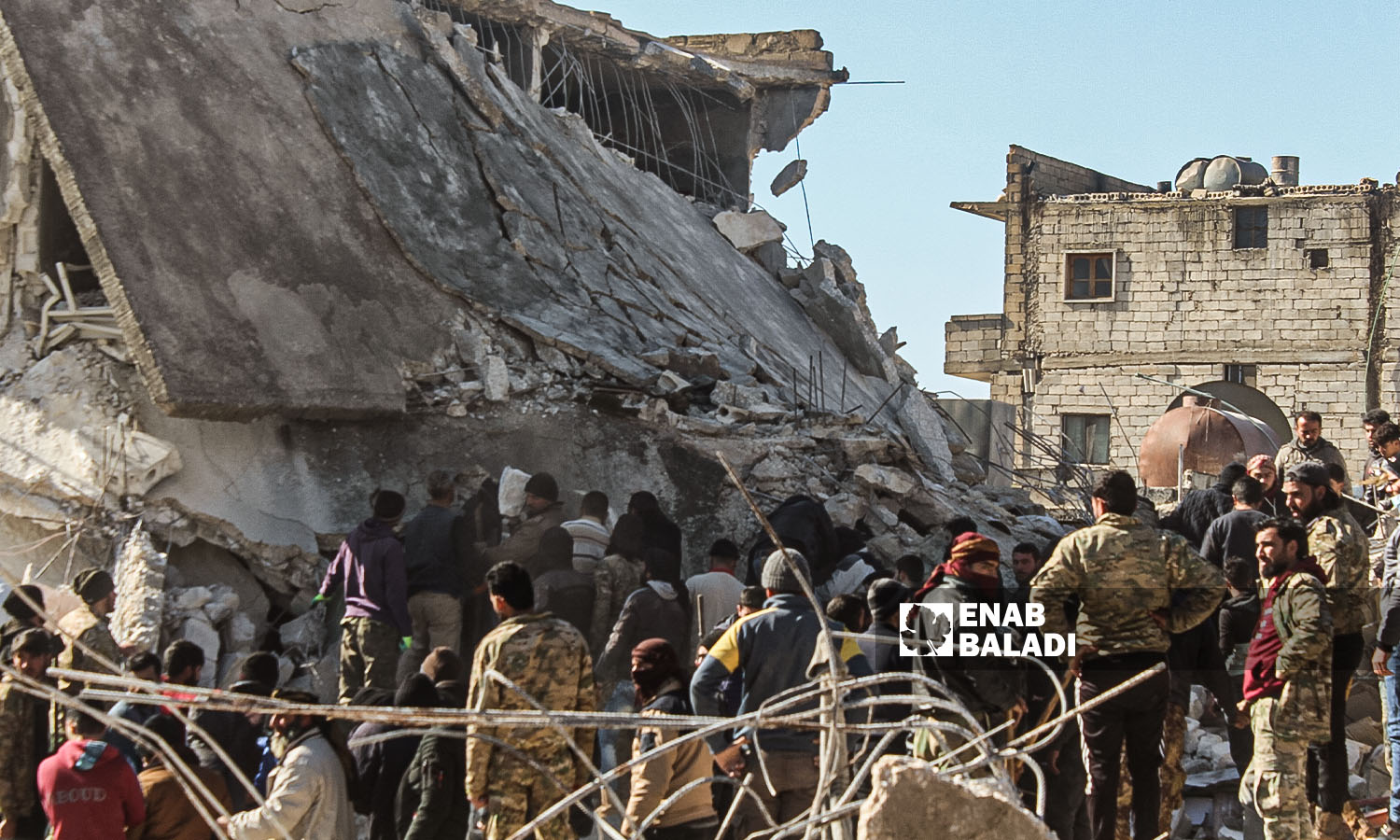 متطوعون من "الدفاع المدني السوري" و سكان متطوعون  يبحثون عن الضحايا والناجين وسط أنقاض المباني المنهارة  في مدينة حارم - 8 شباط 2023 (عنب بلدي/ إياد عبد الجواد)