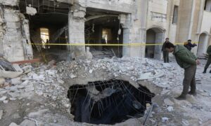 عناصر من قوات الأمن السورية يتفقدون مبنى تضرر في هجوم صاروخي إسرائيلي على حي كفرسوسة في دمشق- 19 شباط 2023 (AFP)