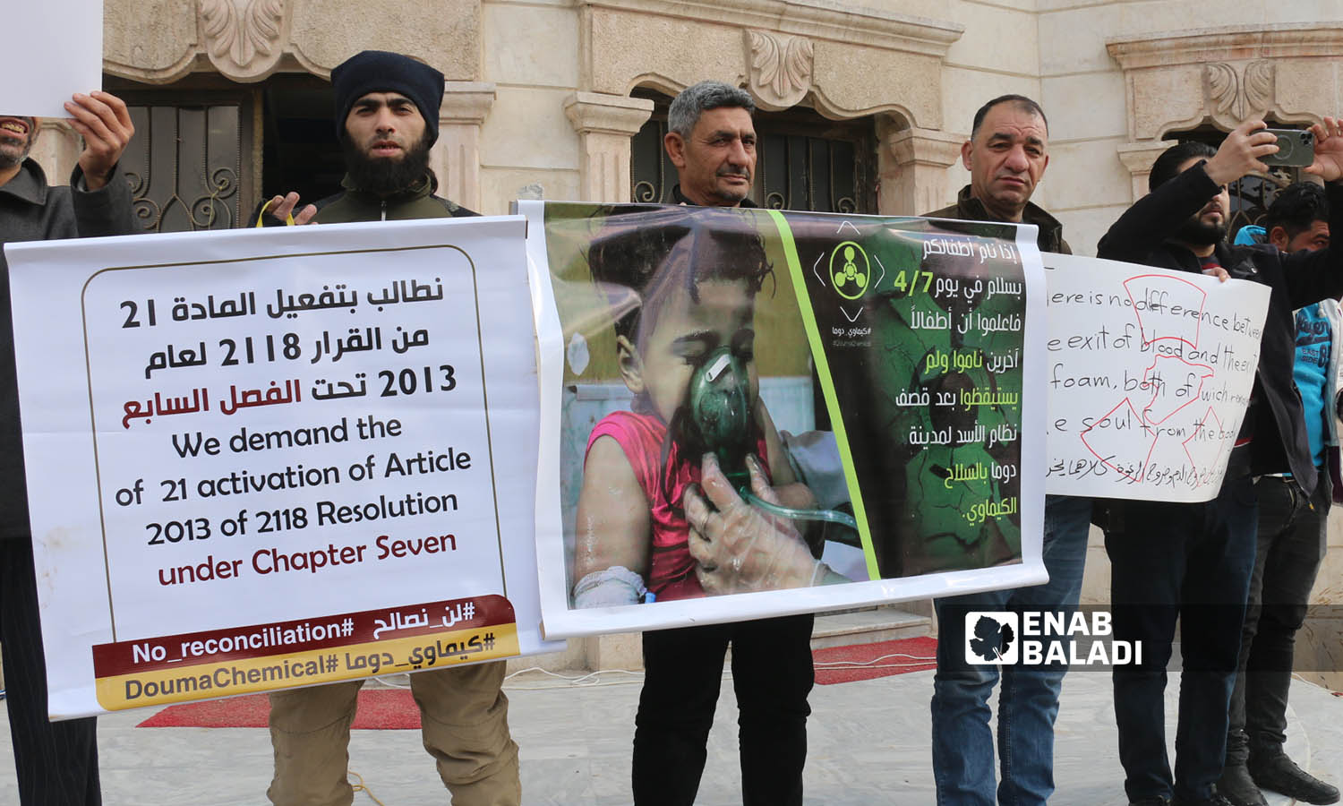 متظاهرون في مدينة اعزاز  يحملون لافتات للتذكير بمجزرة الكيماوي في دوما- 3 من شباط 2023 (عنب بلدي/ديان جنباز)
