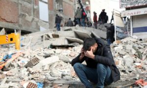 مدني يجلس على ركام منزل دمره الزلزال جنوبي تركيا (رويترز)
