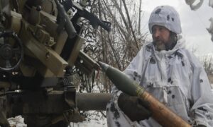 جندي أوكراني يستعد لإطلاق قذيفة مدفعية على مواقع روسية بالقرب من باخموت في منطقة دونيتسك بأوكرانيا - 15 شباط 2023 (AP)