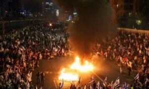 متظاهرون إسرائيليون يشعلون النار في أحد شوارع الداخل الفلسطيني المحتل رفضًا لمشروع الإصلاح القضائي- 26 من آذار 2023 (رويترز)