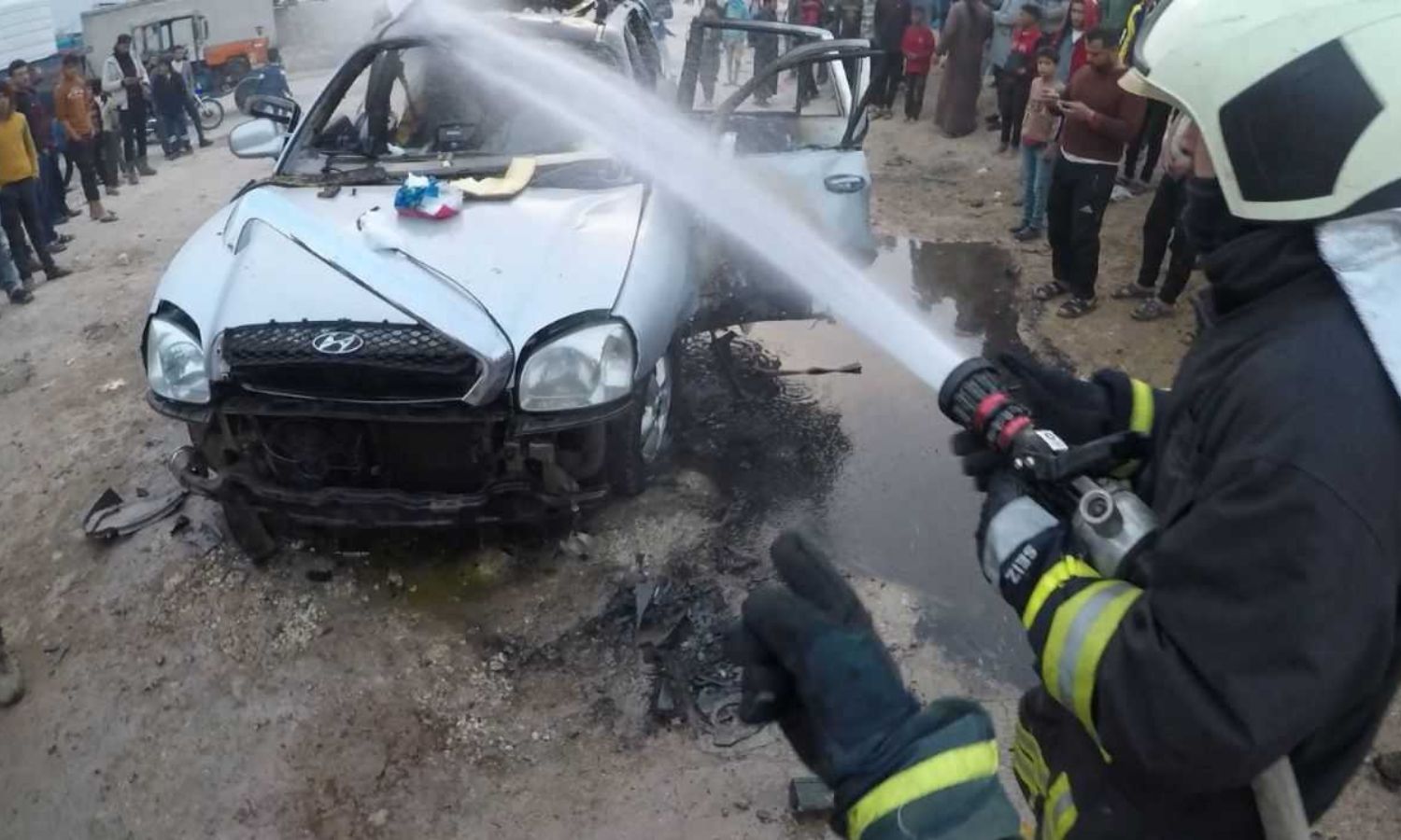 متطوع في "الدفاع المدني السوري" يخمد حريقًا في سيارة تعرضت لعملية تفجير بعبوة ناسفة بريف حلب- 14 من آذار 2023 (الدفاع المدني السوري/ فيس بوك)