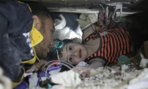 الطفلة شام تحت الأنقاض في بلدة أرمناز بريف إدلب قبيل إنقاذها من فرق 