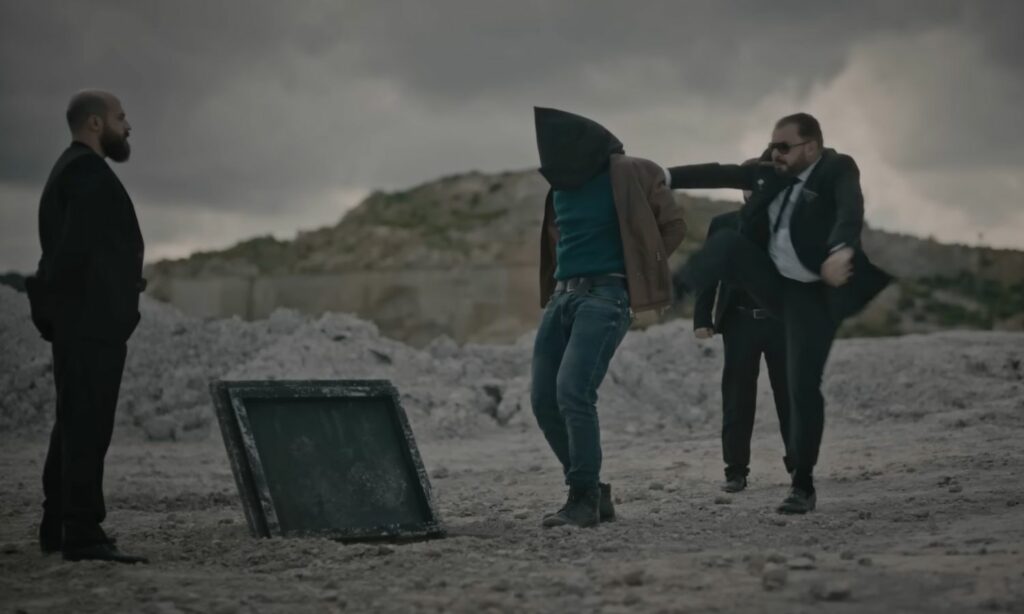 أنيس الرومي يركل جهاد أمام فتحة المعتقل السري الذي أقامه تحت الأرض في أحد مشاهد مسلسل "ابتسم أبها الجنرال"