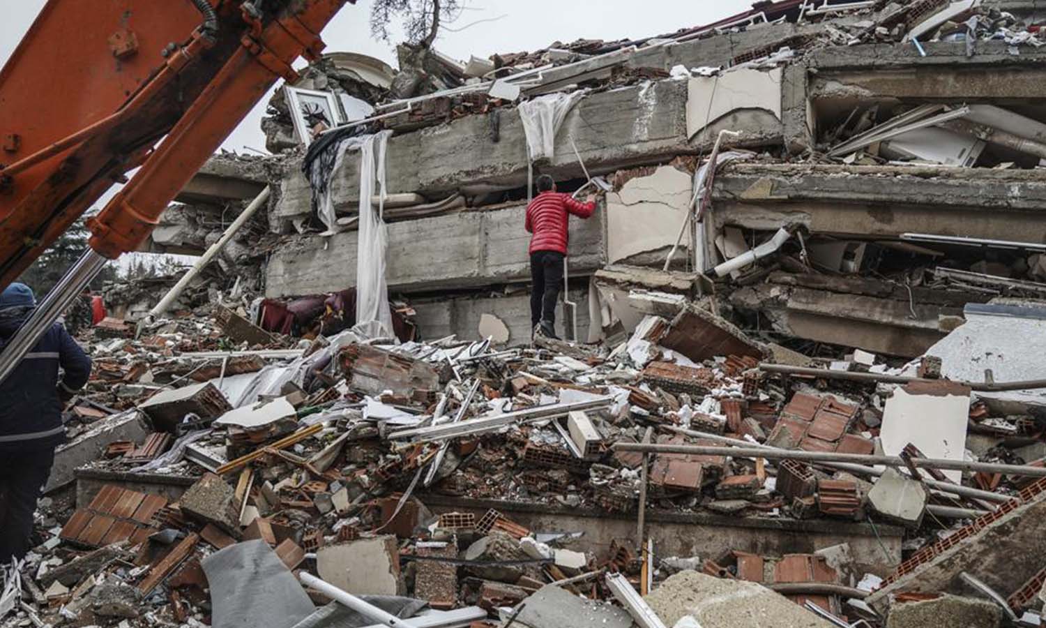 رجل يبحث عن أشخاص تحت أنقاض مبنى مدمر في غازي عنتاب جنوبي تركيا- 6 شباط 2023 (AP)