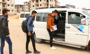 طلاب جامعيون يصعدون إلى حافلة لنقلهم من مدينة إدلب إلى بلداتهم خارج المدينة- 9 من نيسان 2023 (المؤسسة العامة للنقل)
